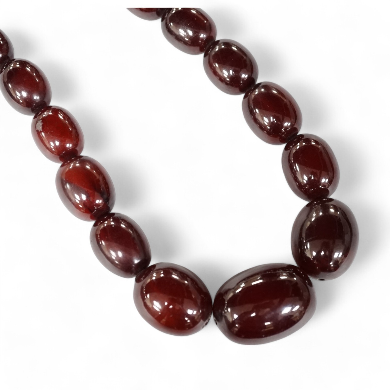 A single strand graduated simulated cherry amber oval bead necklace, 98cm, gross weight 140 grams. Condition - fair to good